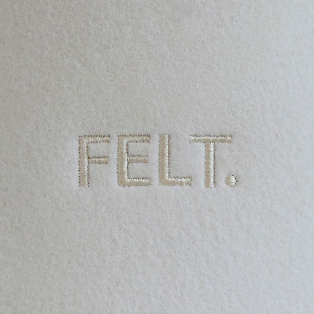 Close-up of the embroidered FELT. logo on Merino wool felt sauna hat