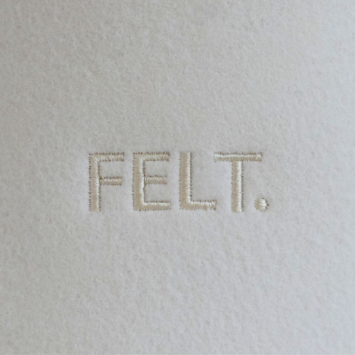 Close-up of the embroidered FELT. logo on Merino wool felt sauna hat
