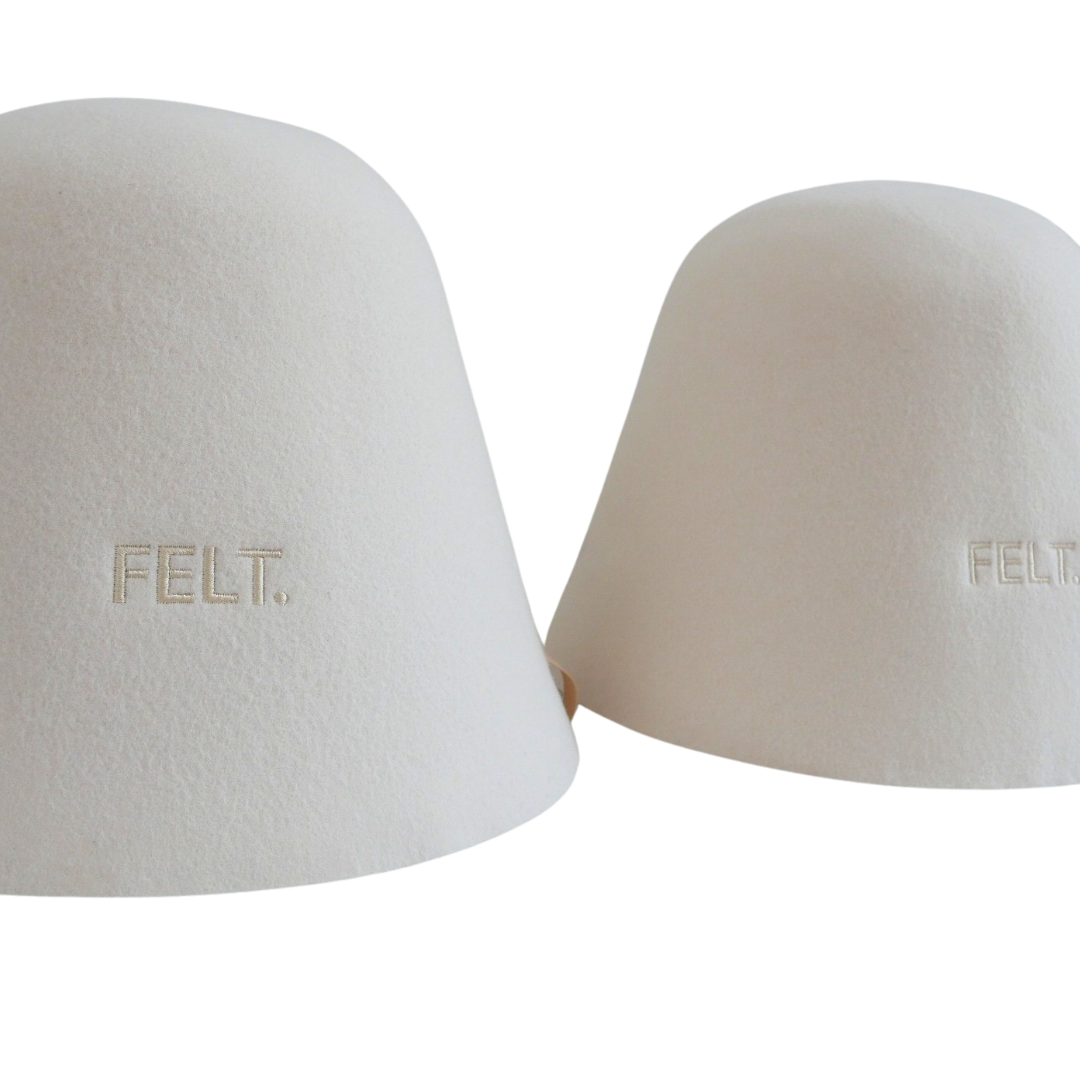Two The Classic merino wool sauna hats in the traditional bell shape, embroidered with the FELT. logo